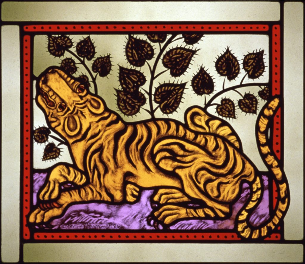 "Animals of the Chinese Zodiac: Year of the Tiger" painted stained glass by Cappy Thompson. A tiger is lying on a purple floor, with its head raised to the left. A plant with heart-shaped leaves spreads across the background.