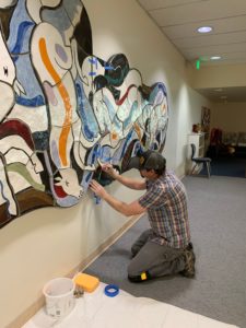 man fixing artwork