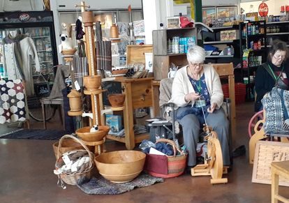 woman weaving on spinning wheel